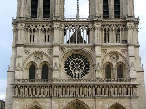 Full west front of Notre-Dame in pale stone, its gallery of kings and rose window stacked beneath the two square towers.