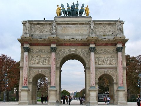 The triple-arched Arc de Triomphe du Carrousel topped by gilded figures and bronze horses, visitors strolling beneath on an overcast day.