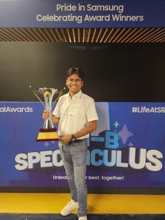 Dr. Pinaki Bhaskar holding the Gallery Search team’s New Valley Project of the Year trophy in front of the SRI-B annual awards backdrop