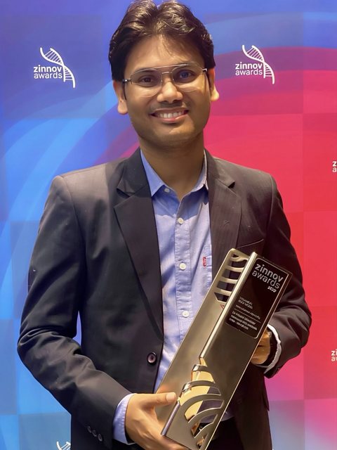 Dr. Pinaki Bhaskar holding the Zinnov Awards 2022 Technical Role Model trophy
