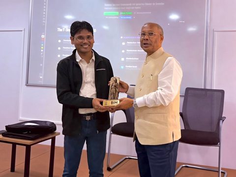 Dr. Pinaki Bhaskar receiving a memento from Prof. Asit K. Barma, Director of BIM Tiruchirappalli, in front of the lecture slides.